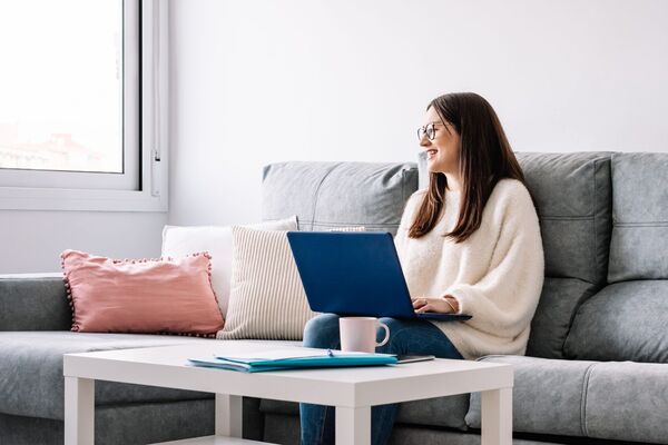 Person sitting on a sofa with a notebook in a calm evening setting